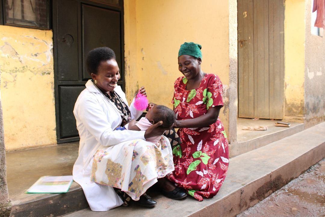 A nurse and mother make time for play during a child's home care visit.