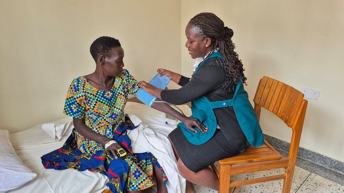 A nurse examines and counsels a woman during an outpatient visit at Mobile Hospice Mbarara.