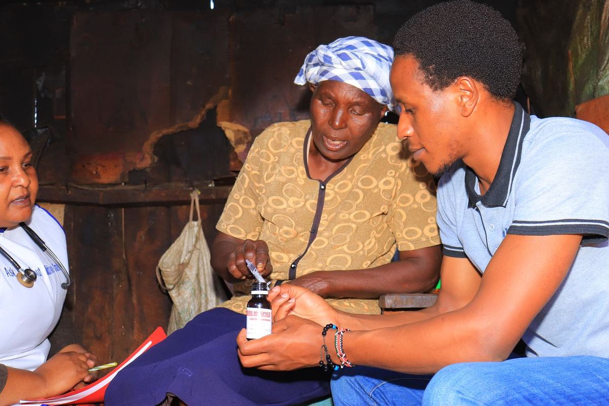 Nurses demonstrate morphine measurement and discuss a patient's questions about her medicines.