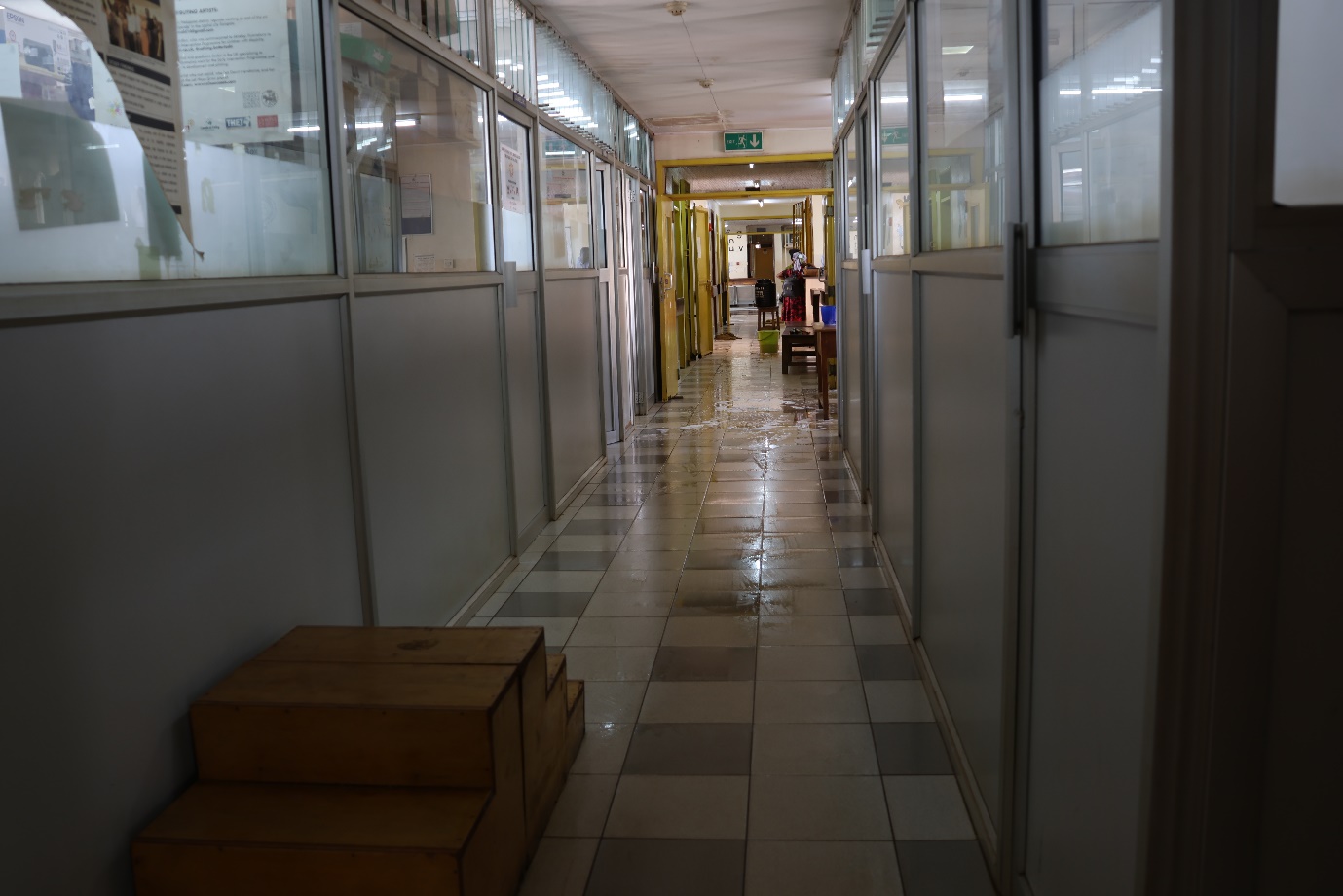 A hallway with glass doors and a tile floor
AI-generated content may be incorrect.