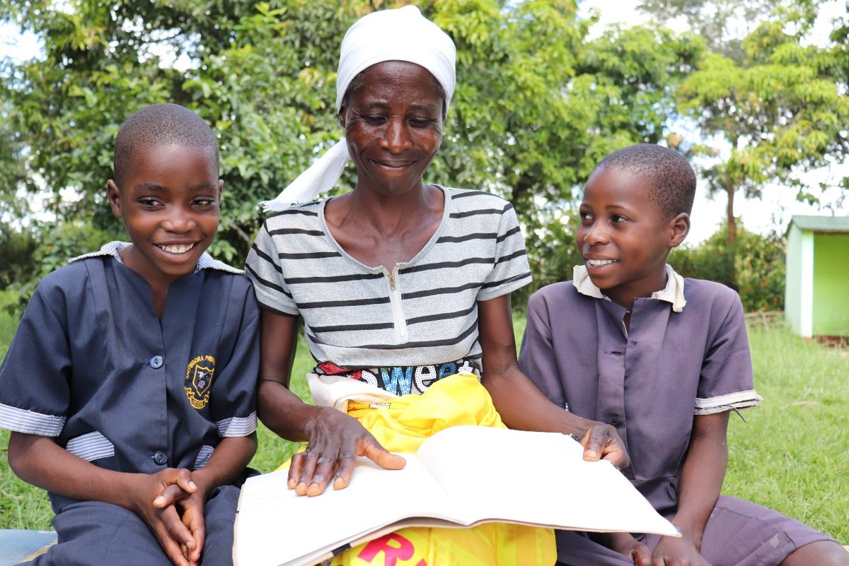 Second place: a mother and her children revisit notes after a childhood cancer awareness session in Raffingora, Zimbabwe