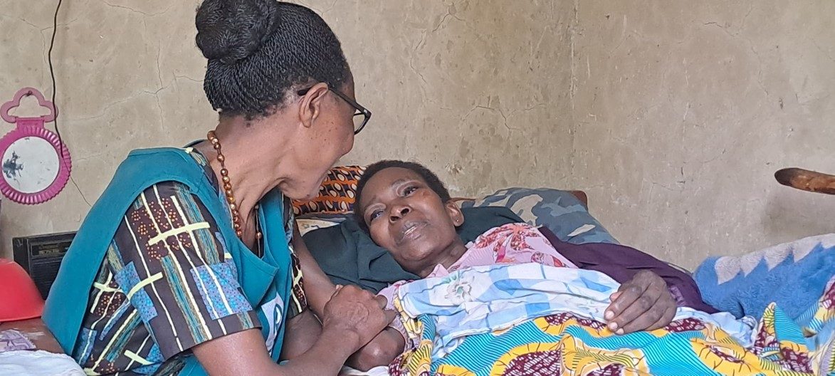 Fifth place: a palliative care provider supports a seriously ill patient and family during a home visit, Mbarara, Uganda